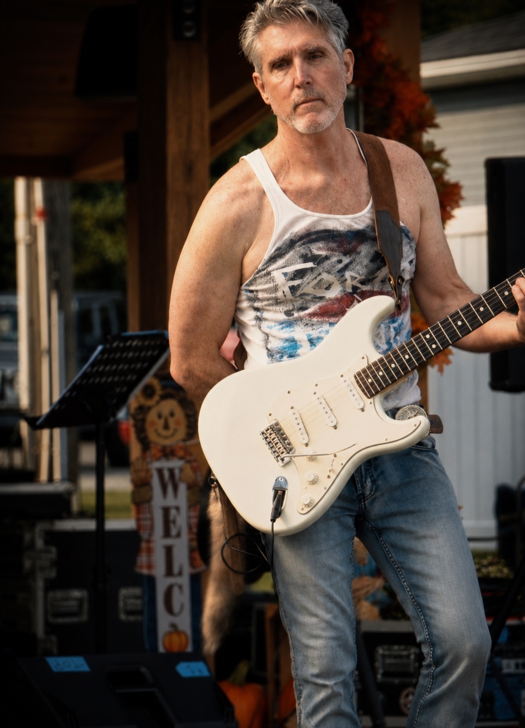 Alex playing white guitar at an outdoor 27 Birds show
